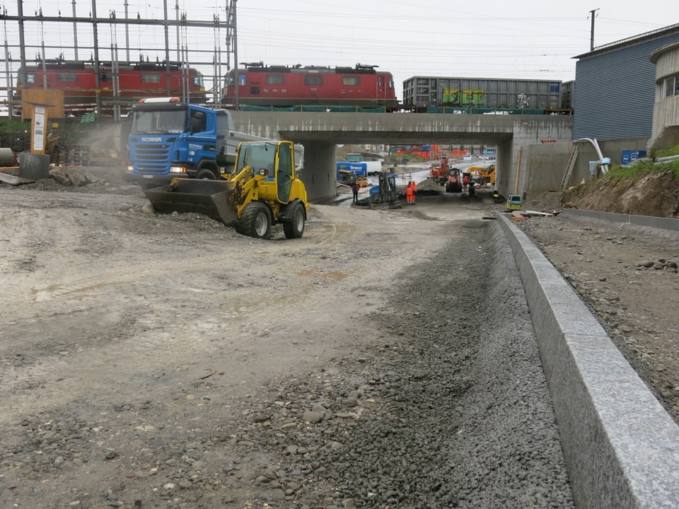 Bagger und Lastwagen auf der Baustelle der Reusseggstrasse.