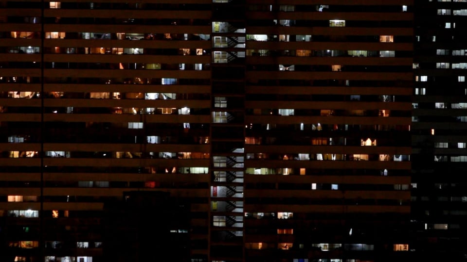 Die Fassade des Torre David bei Nacht mit leuchtenden Zimmern.