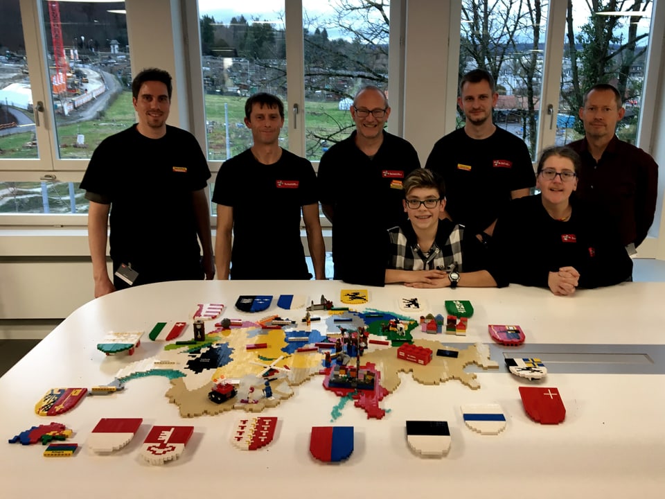 Das Team steht hinter dem Tisch mit der Lego-Schweiz