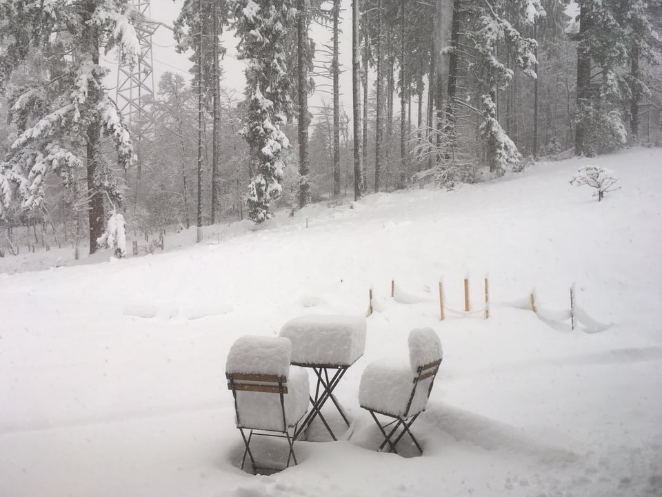Stühle und Bänke und der Garten sind mit Schnee bedeckt