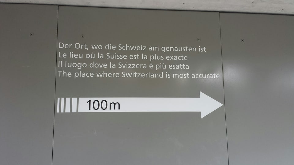 graue Wand mit Aufschrift: Der Ort, wo die Schweiz am Genauesten ist.