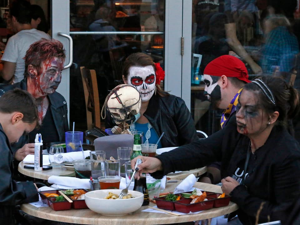 Zombies an einem Restauranttisch mit Essen.