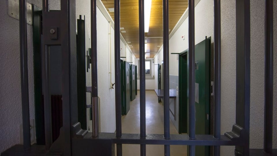 Gefängnisgitter und Zellen im Hintergrund