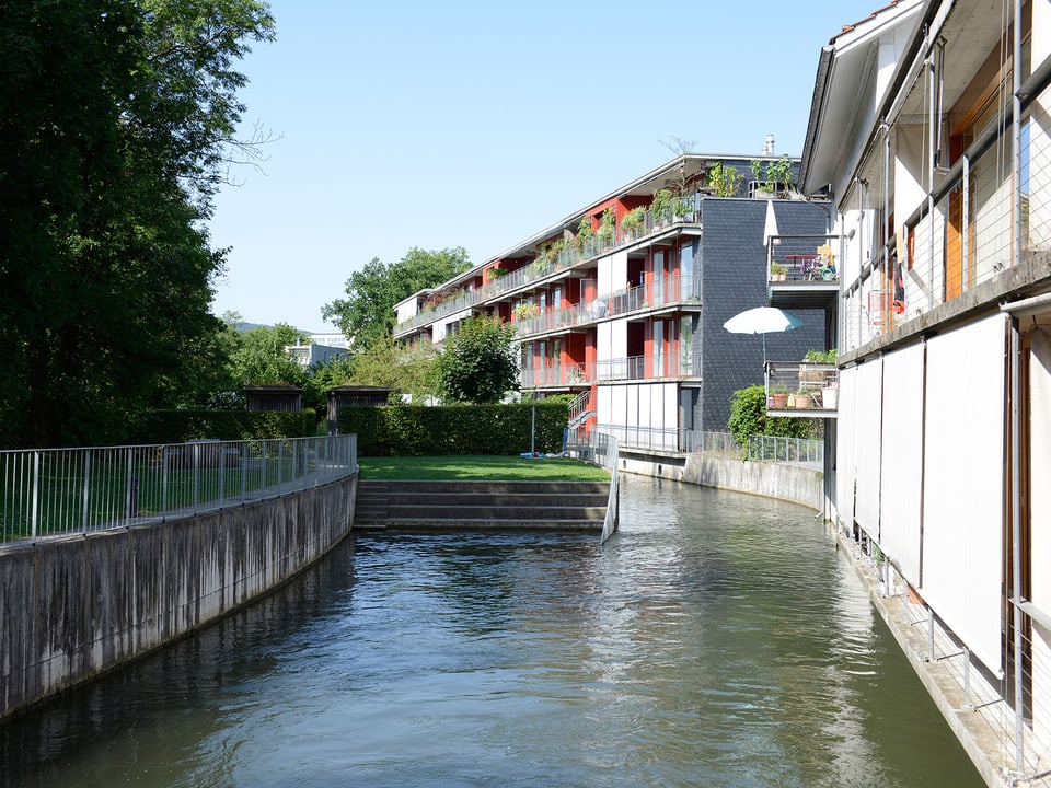 Wohnungen an einem Wasserkanal in Uster. Sie sind direkt ans Ufer gebaut.
