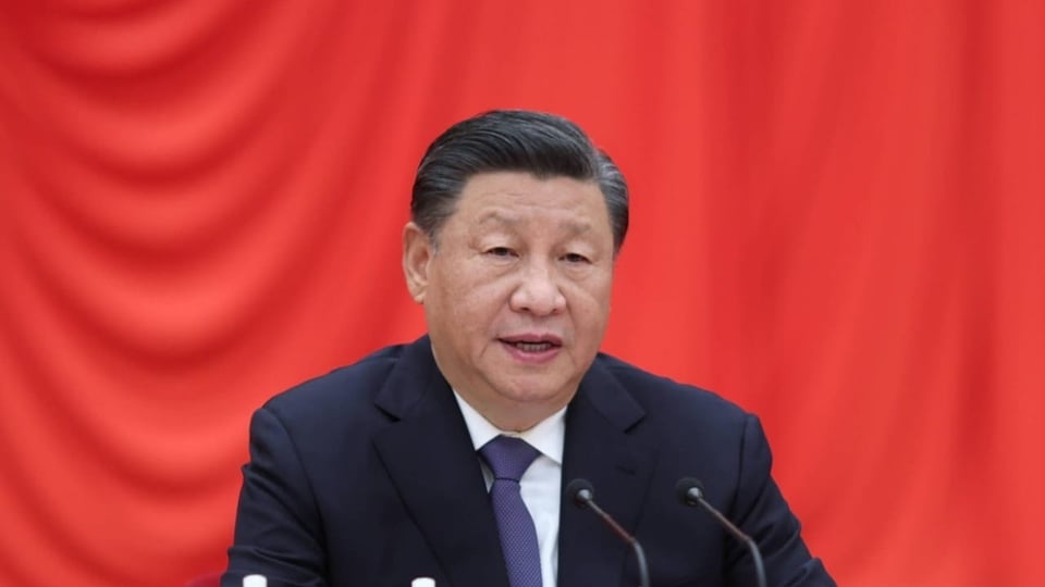 Xi Jinping sitzt an einem Rednerpult und hält eine Rede.