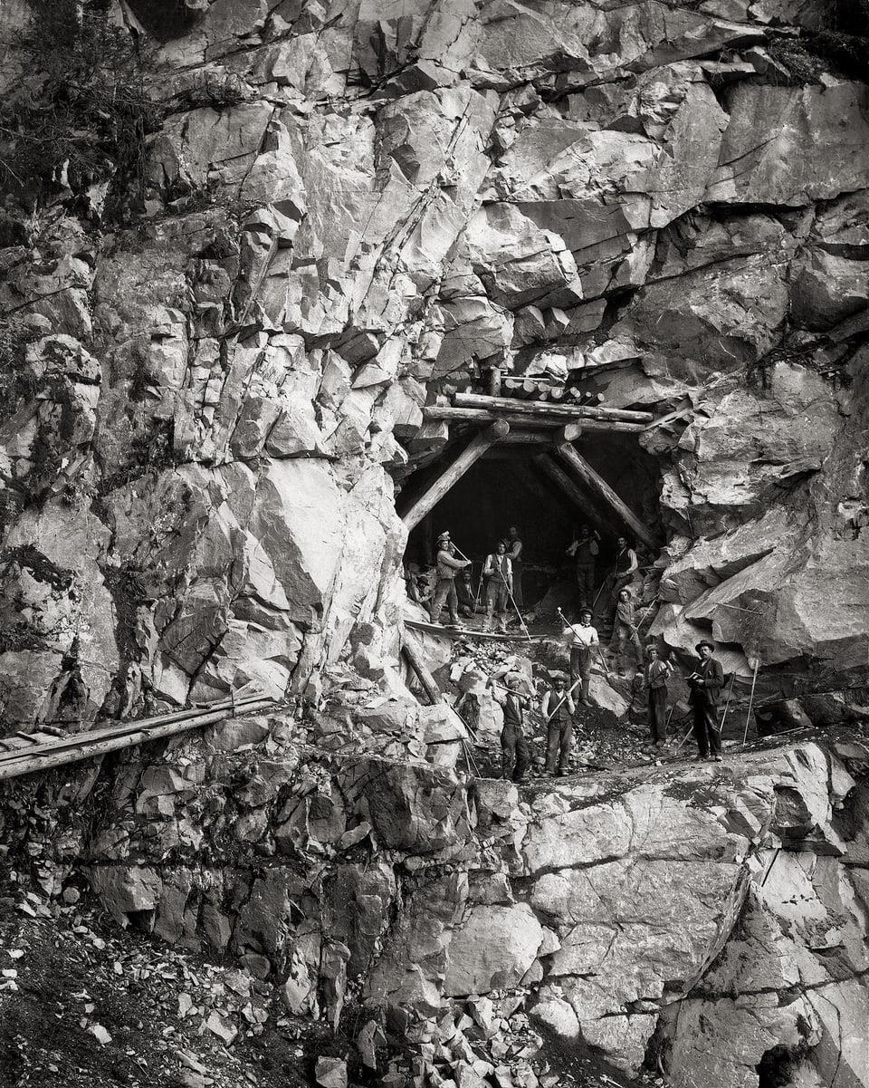 Das Stulsertobel wird mit einer Brücke überwunden, die beidseits in einen Tunnel mündet. Das historische Foto zeigt Arbeiter im Einsatz am Tunneleingang.