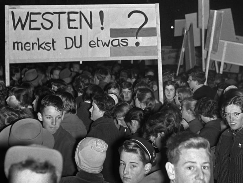 Junge Menschen vor einem Schild mit der Aufschrift «Westen! merkst Du etwas?»