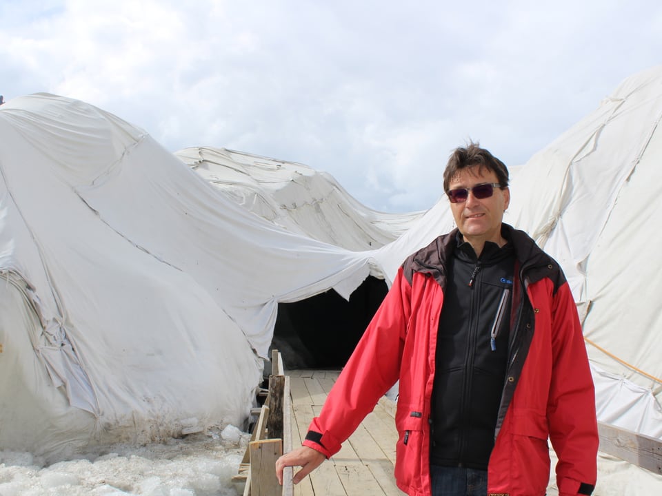 Ein Mann steht vor dem Eingang der Gletschergrotte.