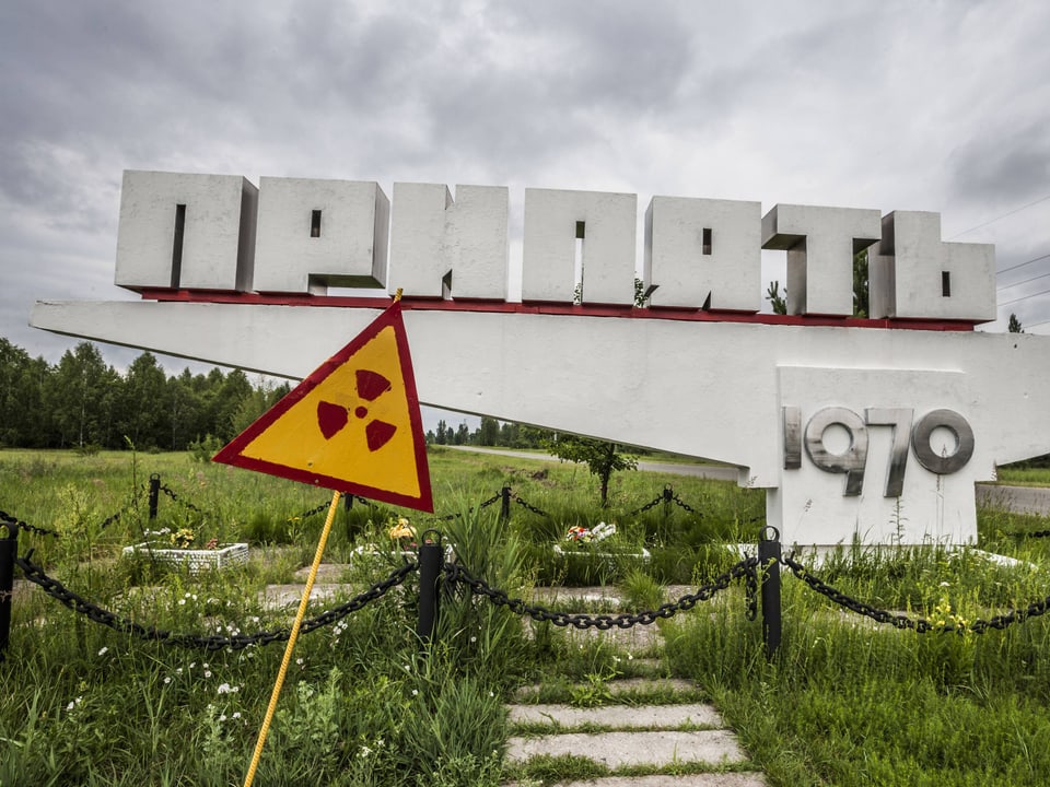 Das Ortseingangsschild von Pripjat mit einem Warnschild vor Radioaktivität.