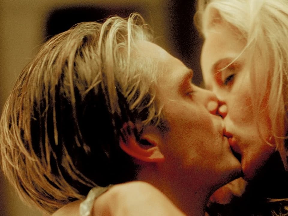 Ein junger Mann und eine junge Frau küssen sich leidenschaftlich.