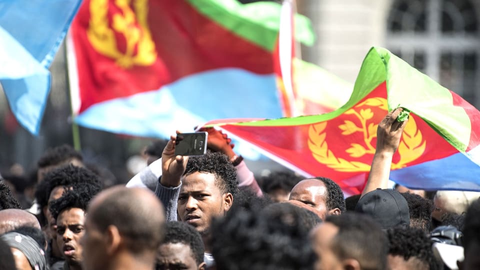 Eritreische Flüchtlinge halten eritreische Flaggen in Bern hoch.