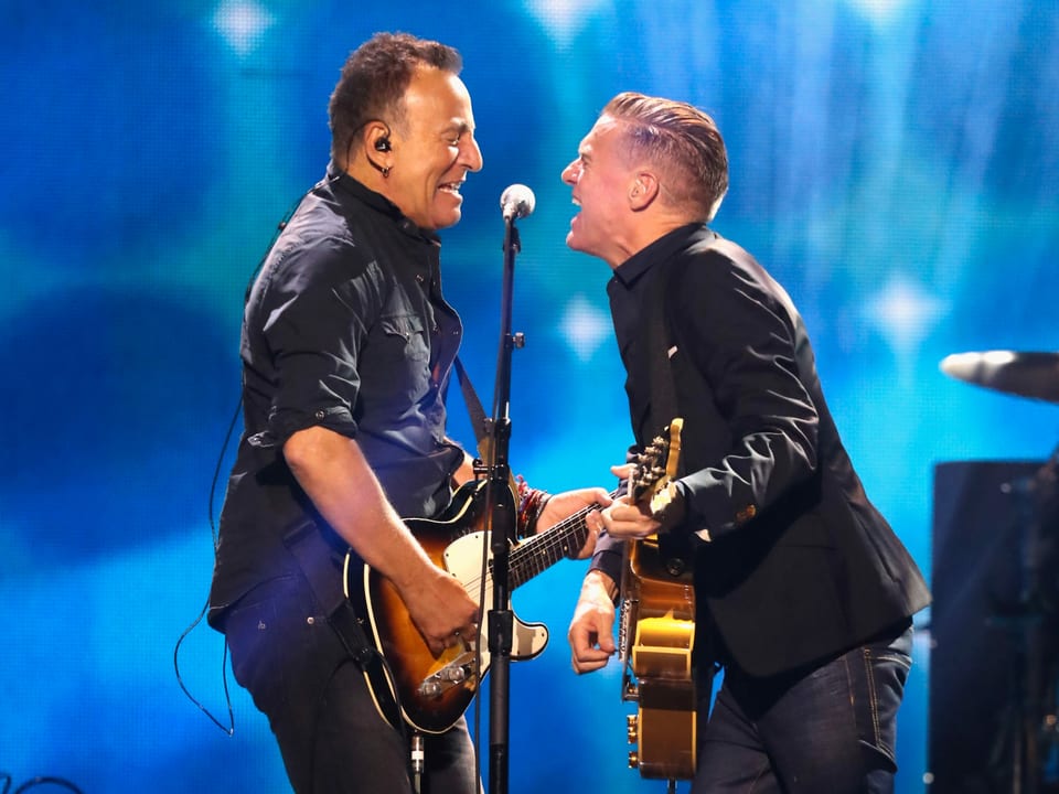 Bruce Springsteen und Bryan Adams stehen auf der Bühne.