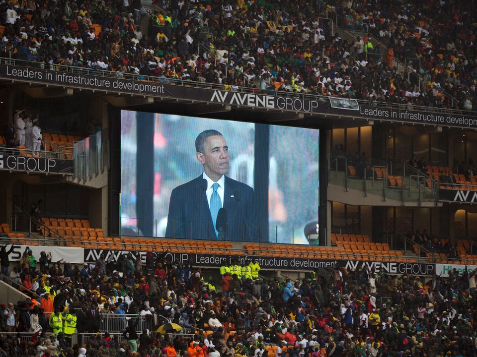 Obamas Bild auf einem Grossbildschirm im Stadion.