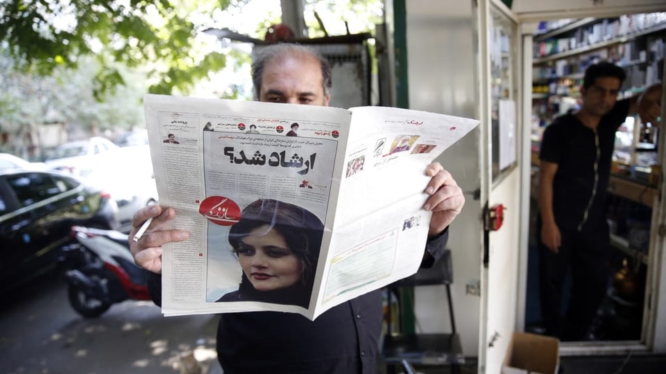 Mann in Teheran liest Zeitung, die über den Tod von Mahsa Amini berichtet.
