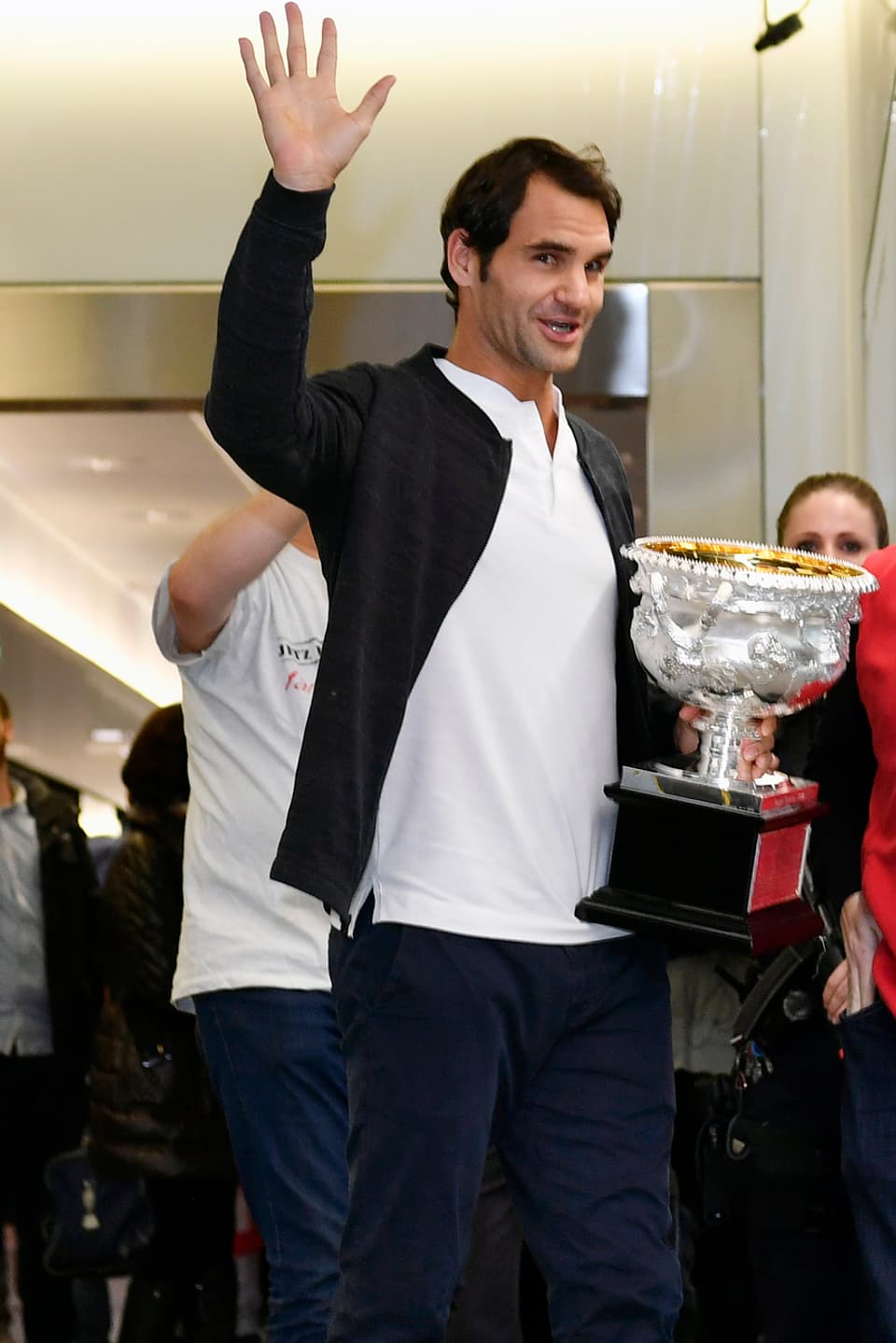 Roger Federer winkt mit dem Pokal.
