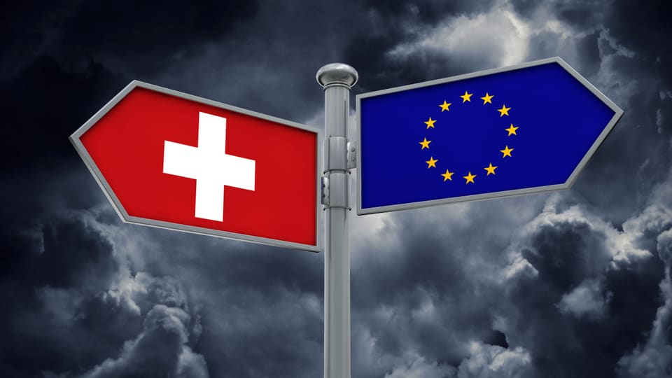 Zwei Wegweiser. Eine Seite zeigt eine Schweizerfahne, die andere eine EU-Fahne