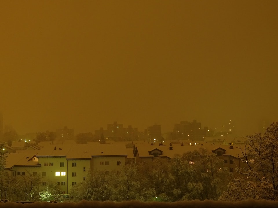Chur bei Nacht mit frisch verschneiten Bäumen und Hausdächern.