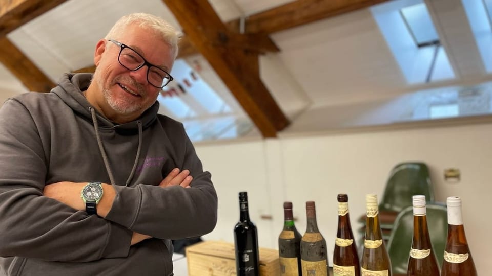 Weintrouvaillen mit Drehverschluss Mann sitzt neben sieben Weinflaschen