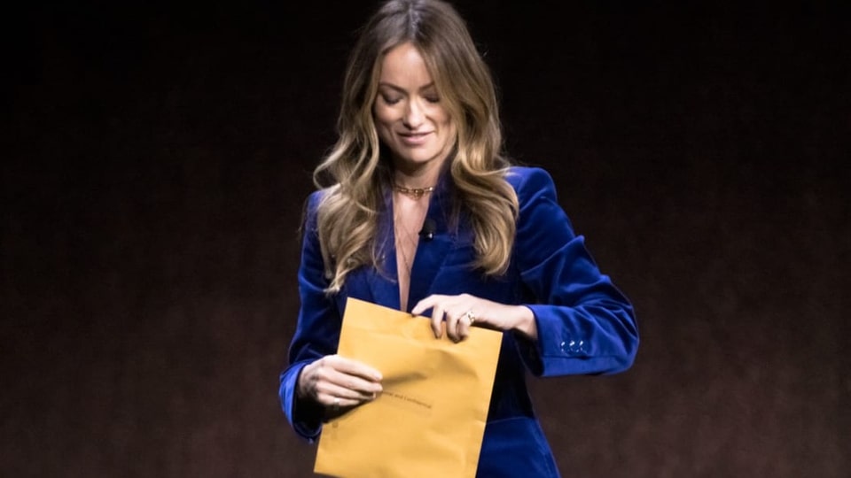 Eine Frau öffnet einen grossen Umschlag.