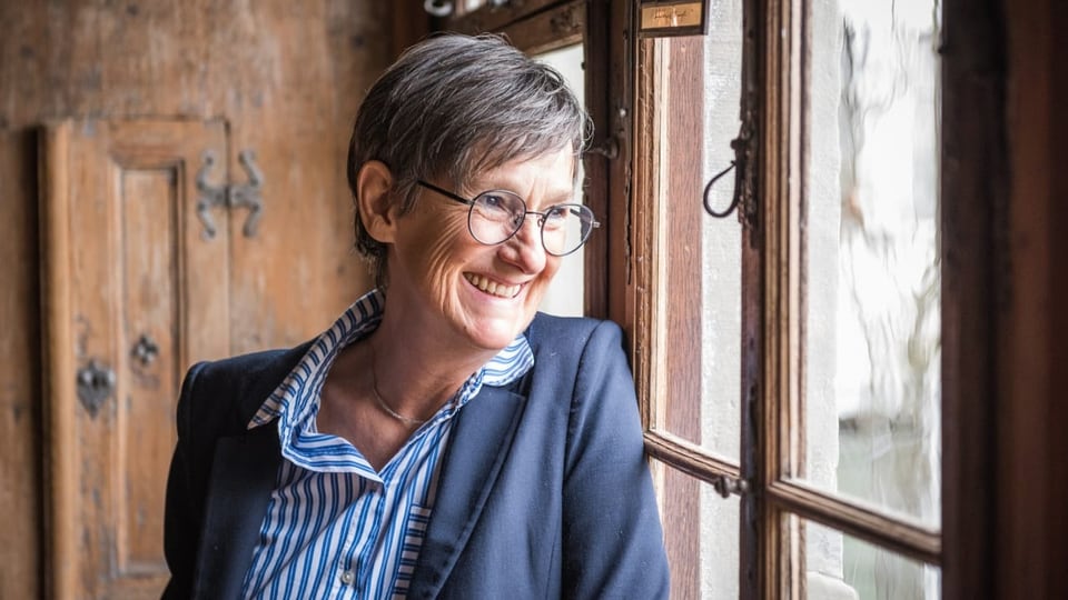 Frau mit Brille in einem Raum mit Holzwänden