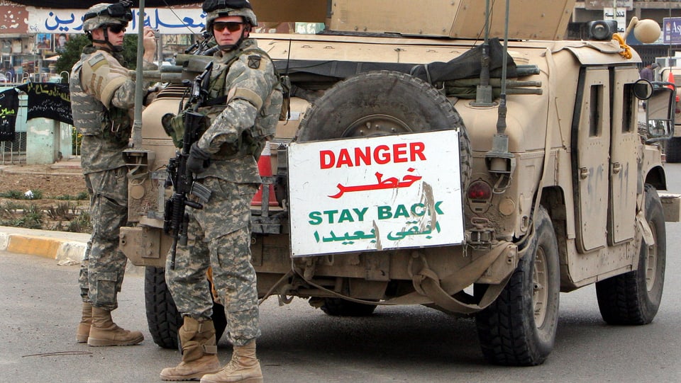 Soldaten vor einem Geländewagen.