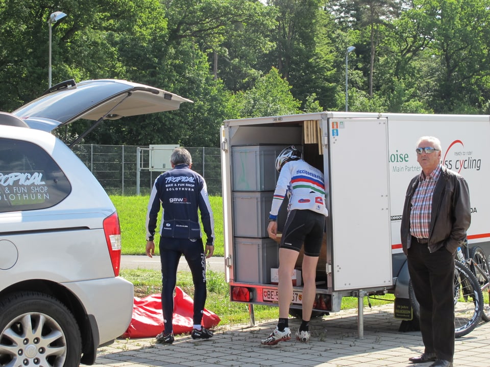 Auto mit Anhänger sowie Mitarbeiter des Radsportlerverbands Swiss Cycling