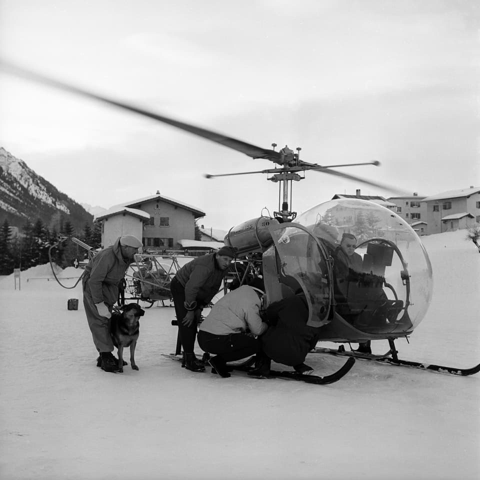 Helikopter wird parat gemacht für Einsatz, davor steht ein Mann mit Hund.