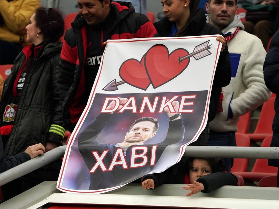 Ein Leverkusen-Fan hält ein Alonso-Plakat.