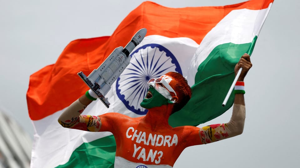 Ein junger Mann mit Bodypainting (Indische Flagge) und einer Rakete