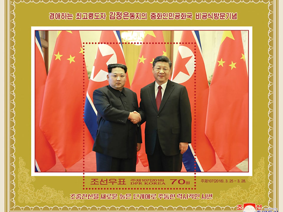 Briefmarke mit Bild, auf dem sich Kim und Xi die Hand geben.