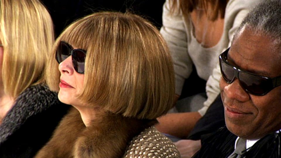 Anna Wintour und ihr Berater sitzen im Publikum einer Show.