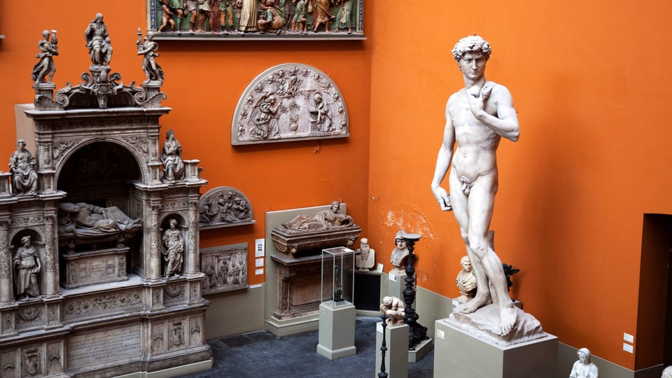 Michelangelos David und andere Stein-Figuren vor der orangefarbenen Wand des V&A Museum