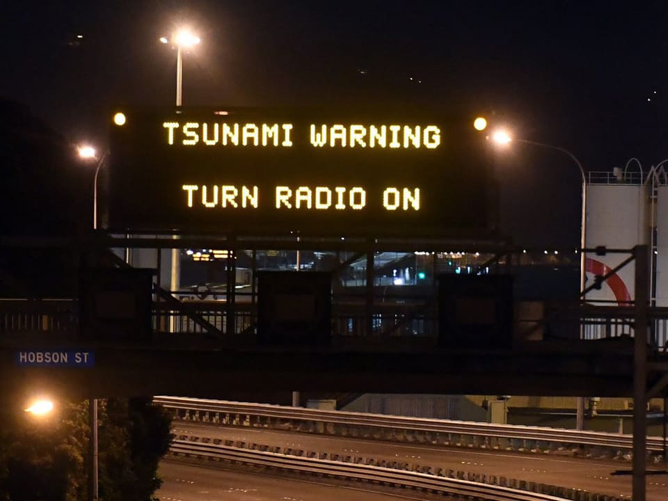 Tsunami-Warnschild über einer Strasse