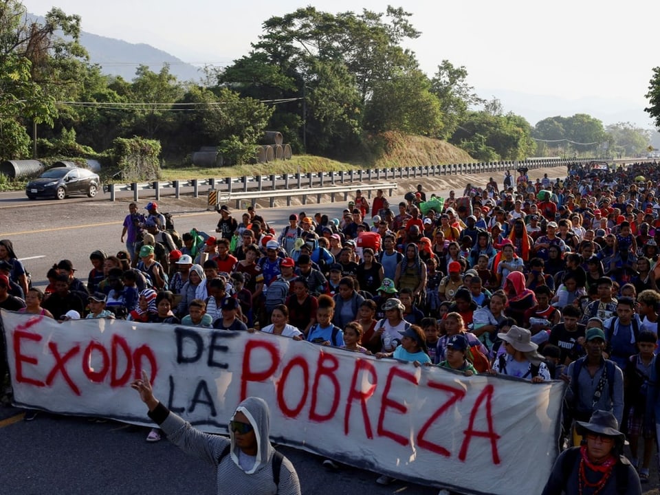 Einige Migrantinnen und Migranten tragen dabei ein Banner mit der Aufschrift «Éxodo de la pobreza»