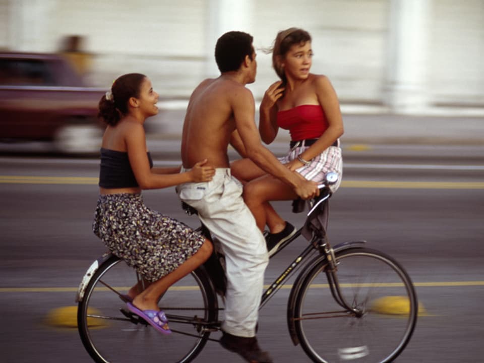 Drei Personen auf einem Fahrrad.