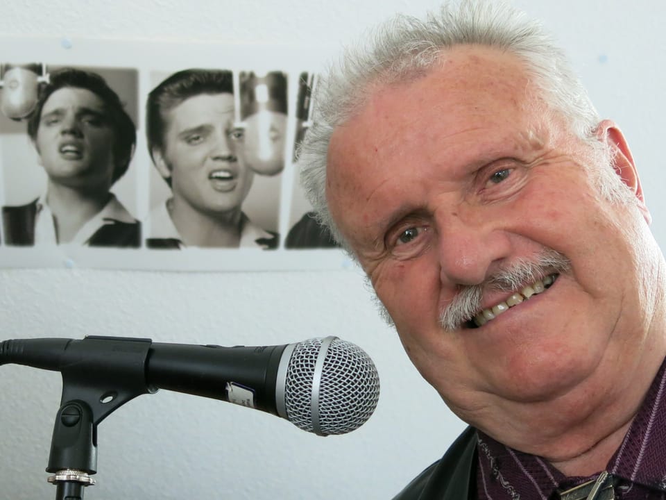 Walter Stettler posiert in seinem Arbeitszimmer vor einem Foto seines Idols Elvis. 