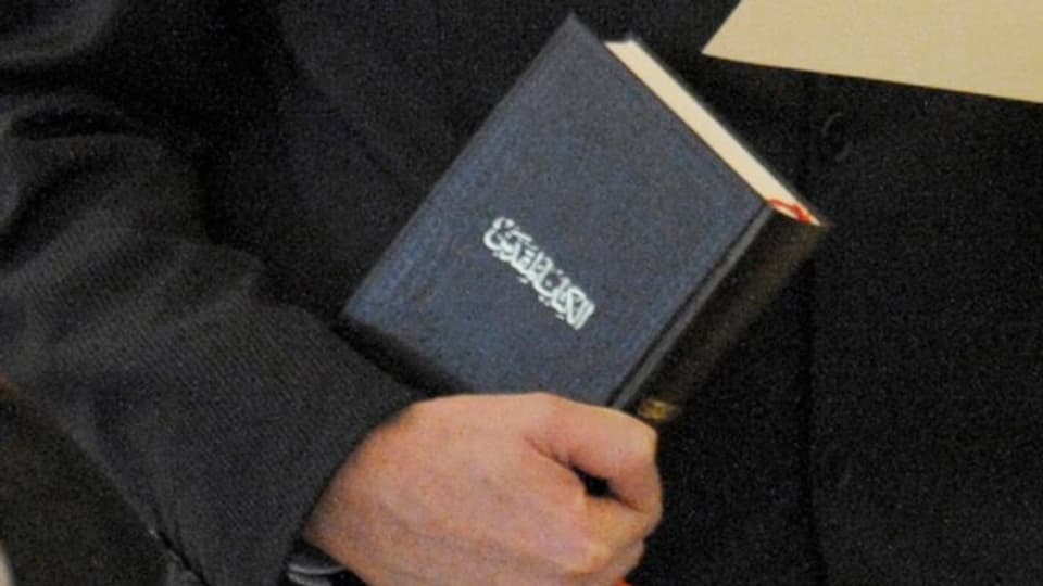Ein Mann mit einem Koran in der Hand