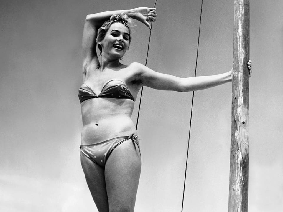 Ursula Andress posiert in Bikini auf Boot.