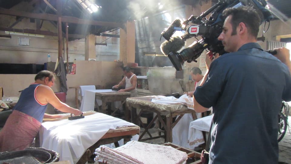 Kameramann filmt Arbeiter in indonesischer Batik-Fabrik.