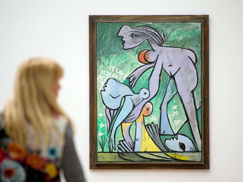 Eine Frau vor einem abstrakten Bild von Picasso.