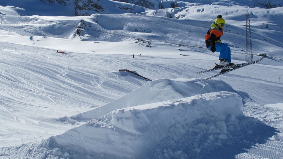 Ein Skifahrer springt über die Schanze.