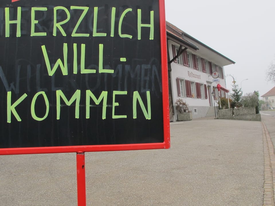 Herzlich-Willkommen-Schild vor dem Restaurant.