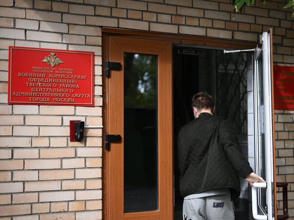 Ein junger Mann betritt ein Büro für die Einberufung zum Militär in Moskau.