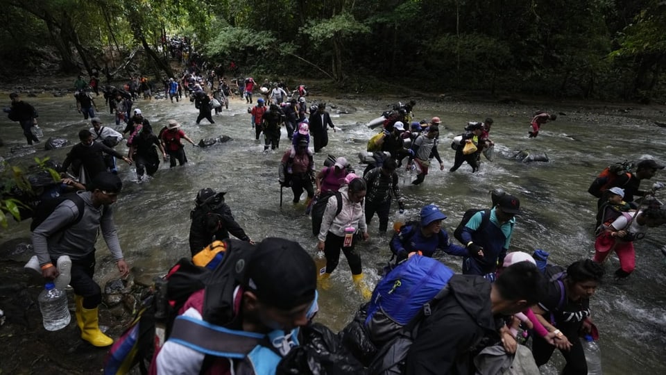 Venezolanische Migranten überqueren einen Fluss im Darién-Dschungel