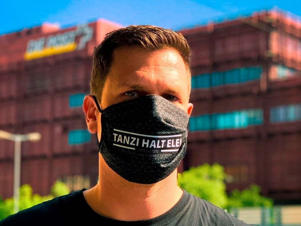 Ein Mann mit einem Mundschutz, darauf steht: «Tanzi halt elei»