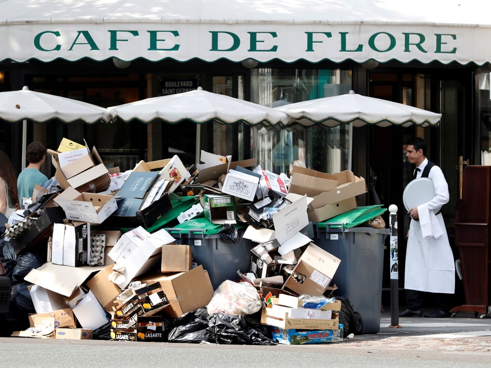 Ein Müllberg vor einem Pariser Café.
