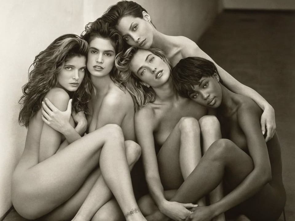 5 sehr bekannte Models aus den 90ern. Sie sitzen alle nackt nahe beieinander auf dem Boden und schauen in die Kamera.