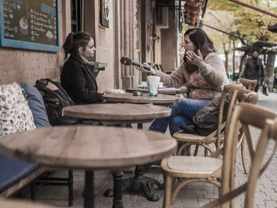 Ukraine-Korrespondentin Judith Huber interviewt eine Frau in einem Café.