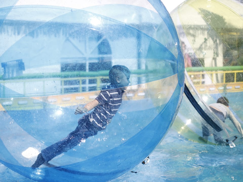 Bub in einem überdimensionierten Wasserball.