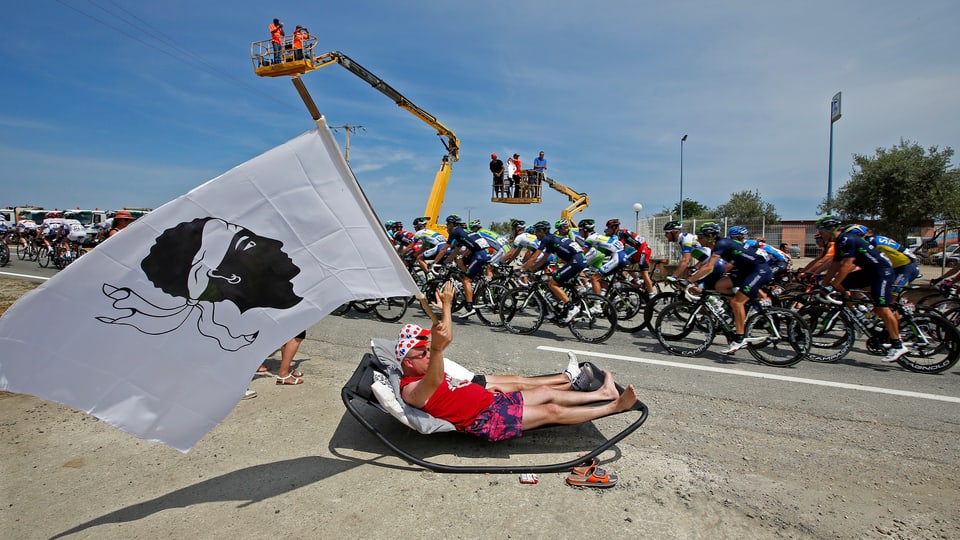 Ein Radsportfan schwenkt die korsische Flagge